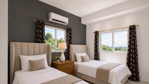 A hotel room with two beds, a nightstand, an air conditioning unit, and large windows with curtains. - Villa with pool near Laguna Gri-Grí and beaches (Río San Juan)