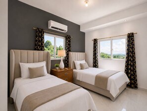 A hotel room with two beds, a nightstand, an air conditioning unit, and large windows with curtains. - Villa with pool near Laguna Gri-Grí and beaches (Río San Juan)