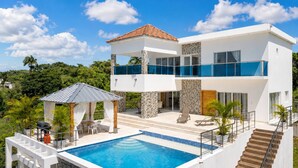 A modern two-story house with a swimming pool, outdoor seating, and a staircase leading to the upper level. - Villa with pool near Laguna Gri-Grí and beaches (Río San Juan)