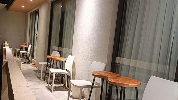 A covered outdoor seating area with tables and chairs, large windows, and a ceiling with recessed lighting. - Marzon Beach Resort (MANOC MALAY AKLAN)