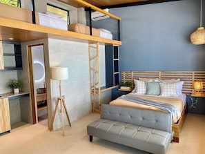 A modern bedroom with a loft bed, bedside table, lamp, and a small plant. - Marzon Beach Resort (Boracay Island)