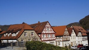 Uma fileira de casas tradicionais de enxaimel com telhados inclinados e um céu azul límpido.