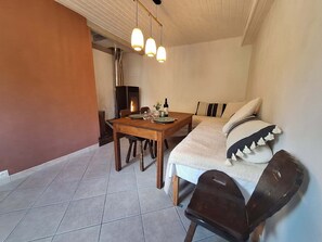 Una stanza accogliente con un tavolo da pranzo in legno, un divano e un camino.