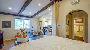 A hotel room with a large bed, a sofa, a dining area, and a view of the outside. - SoCal Studio w/ Pool & Hot Tub Access (Rancho Santa Margarita)