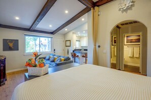 Habitación de hotel con una cama grande, un sofá, un comedor y vistas al exterior.