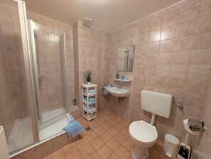 A bathroom with a shower, toilet, sink, and a mirror. - Landgasthof Pension zum Ross (Berg bei Neumarkt in der Oberpfalz)