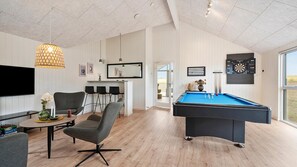 A modern living room with a pool table, a dining area with chairs, a television, and a dartboard. - VillaVilla 957 - Skåstrup Strand, Fyn og øer (Bogense)