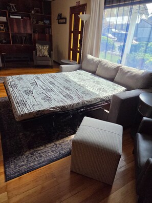 Une pièce comprenant un grand lit, un canapé, une petite table et une bibliothèque.