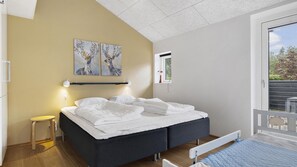 A bedroom with a bed, bedside table, artwork, and a window. - VillaVilla 985 - Øster Hurup, Østjylland (Hadsund)