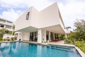 A modern house with a swimming pool, large windows, and a covered outdoor seating area. - Sea Cloud Residence (Tambon Wichit)