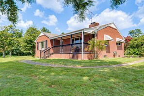A two-story brick house with a covered porch and a satellite dish. - Quiet Stuart Retreat w/ Yard & Fireplace (Stuart)