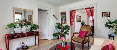 A living room with a sofa, armchair, coffee table, and a console table with a mirror and decorative items.