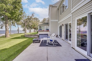A house with a patio, outdoor furniture, a fire pit, and a view of the water. - Mille Lacs Lakefront Townhome: Walk to Marina! (Onamia)
