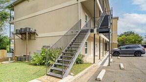 Un immeuble à plusieurs étages, avec un escalier métallique menant à l’entrée.