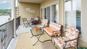 Un balcon avec une table, des chaises et un canapé.