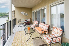 Een balkon met een tafel, stoelen en een bank.