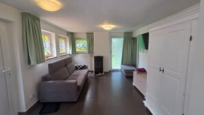 Un salon moderne avec un canapé, une cheminée et un téléviseur fixé au mur.
