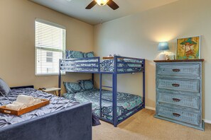 A bunk bed with patterned bedding, a desk with a lamp, and a dresser with drawers. - Las Cruces Oasis: Patio, Hot Tub + Mtn Views (Las Cruces)