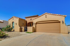 A single-story house with a garage, a small entryway, and a landscaped front yard. - Las Cruces Oasis: Patio, Hot Tub + Mtn Views (Las Cruces)