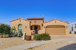 A residential house with a garage, a front door, and a small garden with cacti. - Las Cruces Oasis: Patio, Hot Tub + Mtn Views (Las Cruces)
