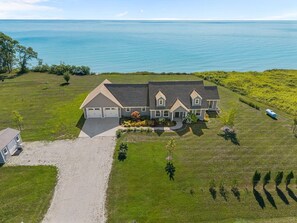 A large house with a driveway, a garage, and a lawn.