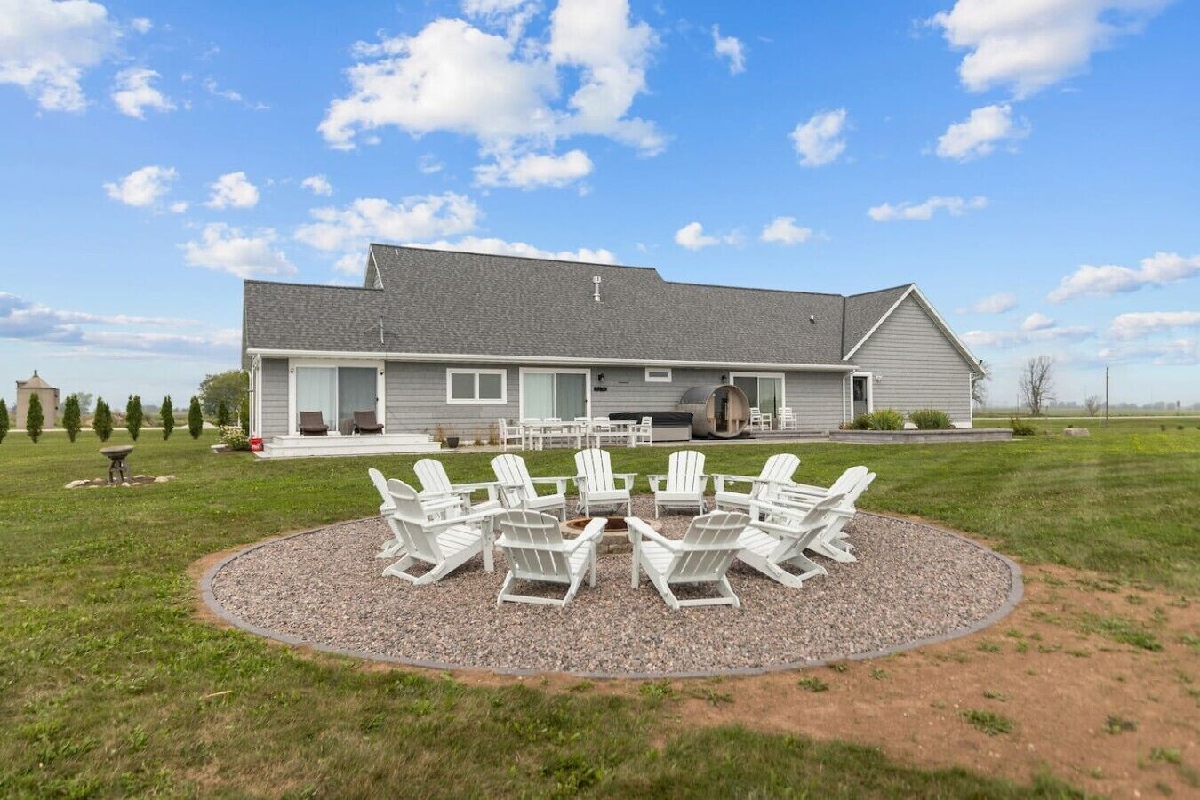 A house with a patio area featuring outdoor seating and a grill.