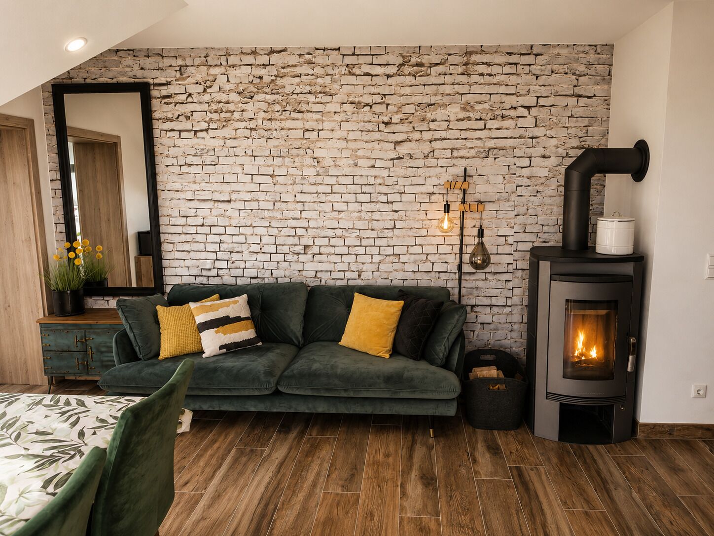 Una sala de estar acogedora con un sofá verde, una chimenea y una pared de ladrillo.