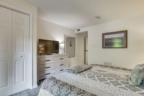 A bedroom with a bed, a dresser, a television, and a framed picture on the wall. - Lake Days, Pool Vibes! Family Retreat in Poconos (Lake Harmony)