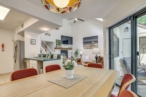 A modern kitchen with a flat-screen TV, a dining area with a wooden table and chairs, and a living room with a sofa and a painting. - Lake Days, Pool Vibes! Family Retreat in Poconos (Lake Harmony)