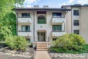 A multi-story building with a central entrance, balconies, and a stone pathway leading to the door. - Lake Days, Pool Vibes! Family Retreat in Poconos (Lake Harmony)