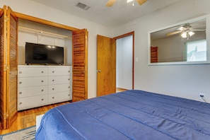 A bedroom with a bed, a television on a dresser, and a mirror on the wall. - Mary Esther Family Home, 9 Mi to Navarre Beach! (Mary Esther)