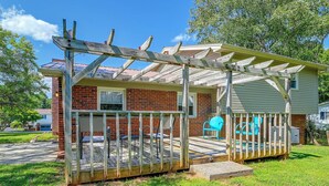 Ein Wohnhaus mit Backsteinfassade, einer Holzterrasse und einer überdachten Veranda.