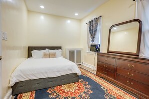 A bedroom with a bed, dresser, and a large mirror. - Near Shops & Transit to NYC! Yonkers Apt (Yonkers)
