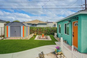 A residential property with a fenced yard, a small shed, and a house with a green exterior. - Spacious, Cozy Rear House Near LAX (Compton)
