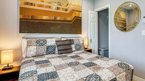 Ein Schlafzimmer mit einem großen Bett, einem Wandspiegel und einem Gemälde.