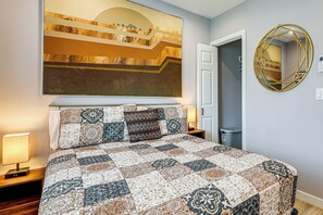 Una camera da letto con un letto grande, uno specchio a muro e un quadro.