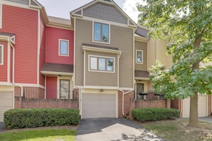 A row of townhouses with a garage, brick facade, and a well-maintained lawn. - Home Gym & Office! Townhome Walk to Genesee River (Rochester)