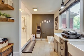 A modern bathroom with a shower, toilet, and sink. There are towels and a rug on the floor. - Home Gym & Office! Townhome Walk to Genesee River (Rochester)