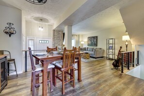 A spacious living area with a dining table, chairs, a sofa, and a guitar. - Home Gym & Office! Townhome Walk to Genesee River (Rochester)