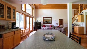 Una cocina amplia con armarios de madera, una isla grande y un comedor con sofá y sillas.