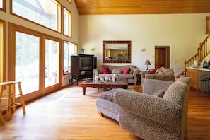 A spacious living room with a fireplace, a sofa, and a television. - PNW Island Escape! Golf & Unwind in Nature (Everett)