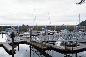 A marina with boats docked at wooden piers, calm water, and a cloudy sky. - PNW Island Escape! Golf & Unwind in Nature (Everett)