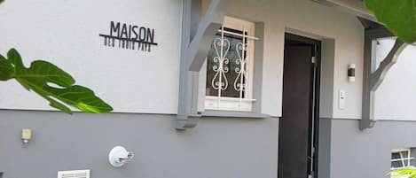 A building with a sign reading 'MAISON' and a door.