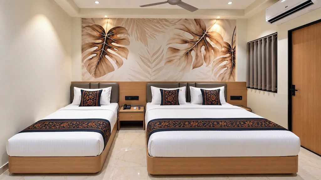 Habitación de hotel con dos camas, ventilador de techo, equipo de aire acondicionado y una pared con diseño de hojas.