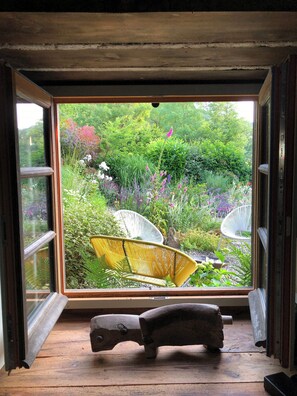 Ein Zimmer mit einem großen Fenster, einer rustikalen Holzbank und einem Stuhl.