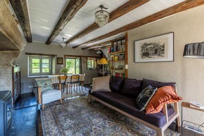 Ein gemütliches Wohnzimmer mit einer Couch, einem Esstisch und einem Bücherregal.
