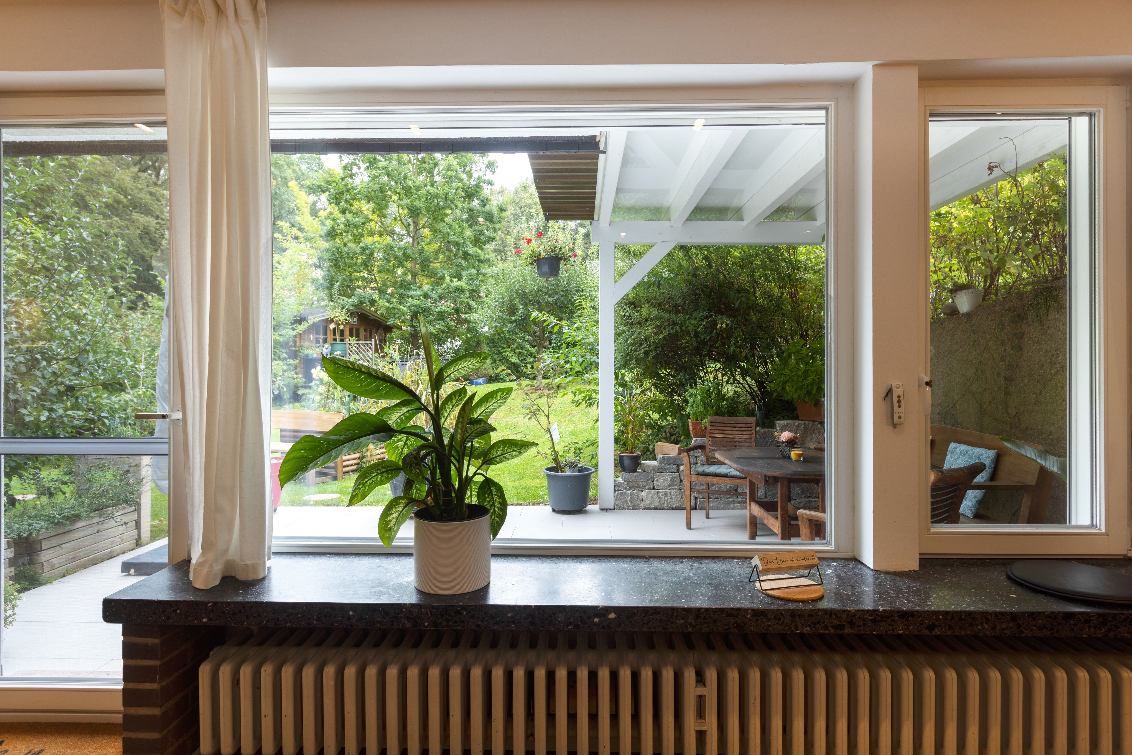 Een kamer met een grote schuifpui die uitkomt op een terras.