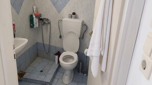 Ein Badezimmer mit Toilette, Waschbecken und Dusche.