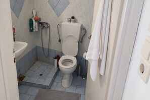 A bathroom with a toilet, sink, and shower. - Akrotiri Flat near Red Beach (akrotiri)