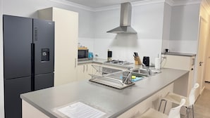 Una cocina moderna con refrigerador, microondas y estufa incorporados.